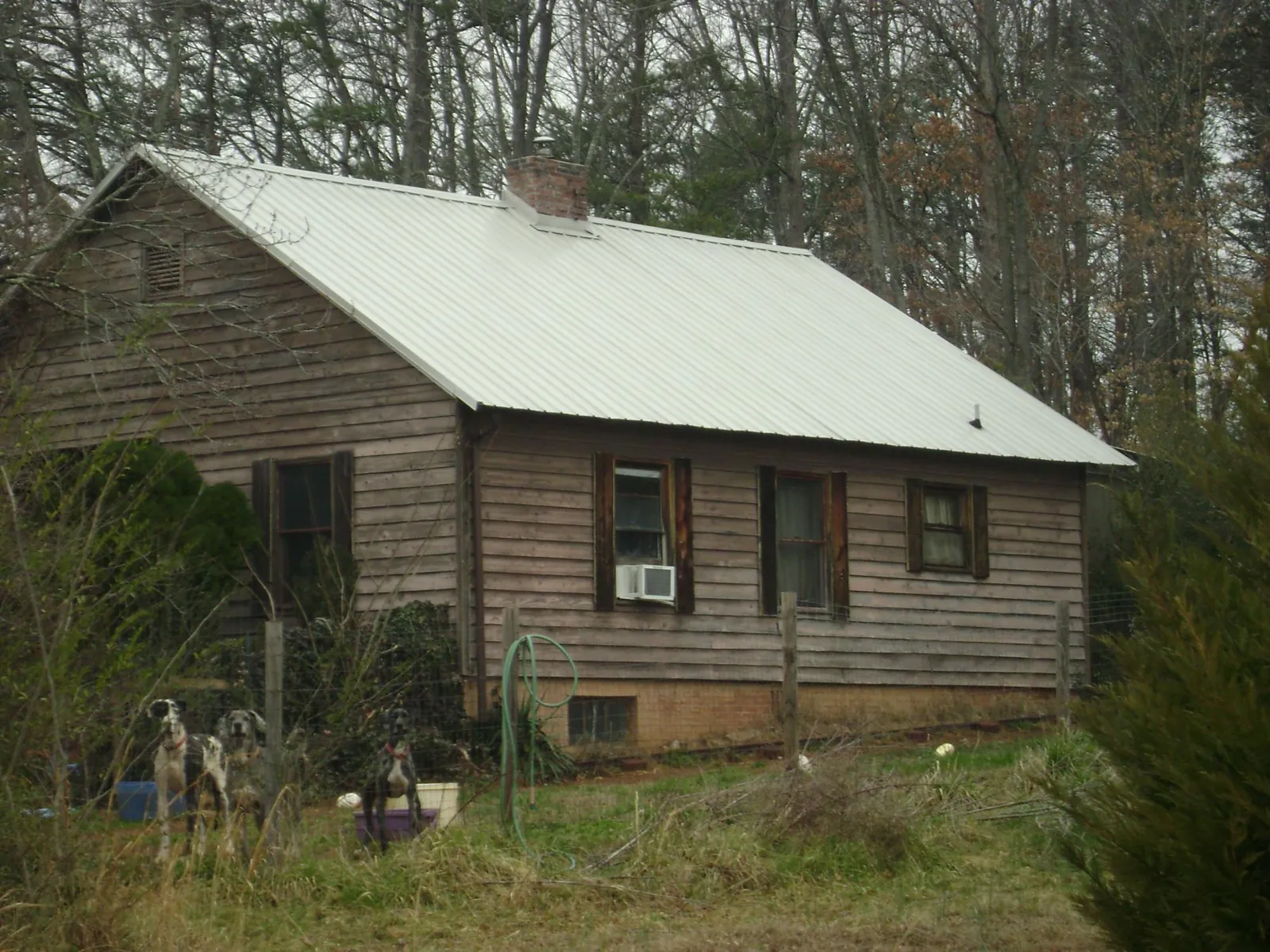White metal roof on an old wood sided farmhouse, from a Metal Roof Installation job in Pikesville